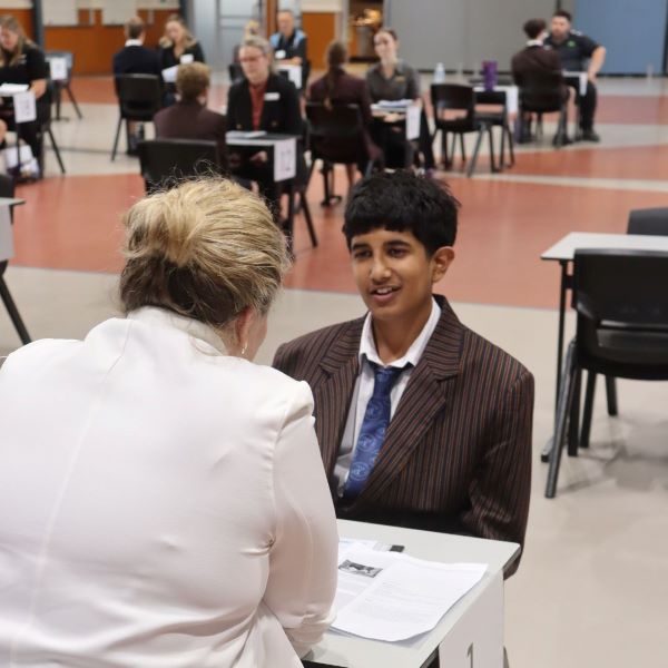 Close up of Emmaus College student being interviewed by a lady in a white blouse