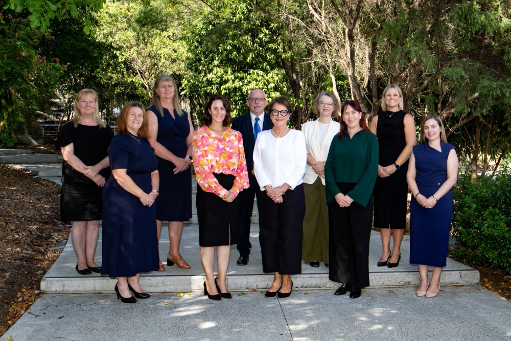 10 School Leaders standing in group smiling for the camera in an outside location