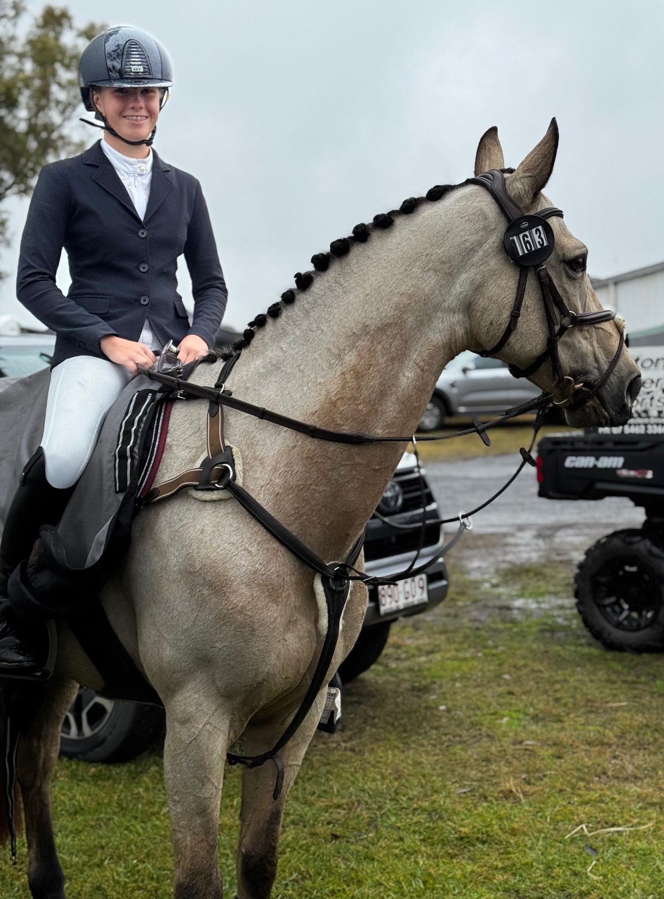 Student riding a horse in competition setting preparing for an equestrian event class=